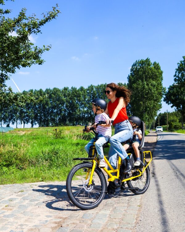 Gele veloe fiets met mama en twee kids